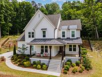 Charming two-story home featuring a covered porch, manicured landscaping, and modern white siding at 1344 Legend Oaks Drive Dr, Chapel Hill, NC 27517
