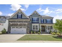 Beautiful home featuring a 2-car garage, a well-manicured lawn, and a classic craftsman-style covered front porch at 155 Annabelle Branch Ln, Apex, NC 27523
