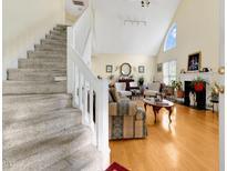 Bright living room with hardwood floors, fireplace, vaulted ceiling, and staircase at 17 Nicklaus Way, Clayton, NC 27520