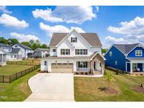 Beautiful two-story home with a white exterior, brown shutters, and a well-manicured lawn in a friendly neighborhood at 2014 Anna Lilley Dr, Fuquay Varina, NC 27526