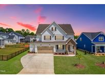 Stunning two-story home featuring a three-car garage, landscaped yard, and classic architectural details at 2014 Anna Lilley Dr, Fuquay Varina, NC 27526