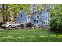 Charming two-story home with light blue siding, well-maintained lawn, and an attached two-car garage at 307 Durington Pl, Cary, NC 27518
