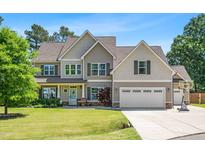 Traditional two-story home with a two car garage, a basketball hoop, and well-maintained landscaping at 311 Ocean Dr, Clayton, NC 27520