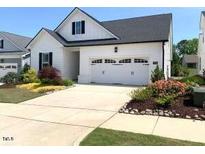 Charming home featuring a two-car garage, well-maintained landscaping, and classic white siding at 3521 Olive Glen Dr, Apex, NC 27502