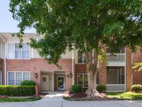 Exterior of a brick building featuring lush landscaping and a mature shade tree enhancing the welcoming entrance at 412 Waterford Lake Dr, Cary, NC 27519