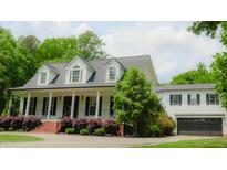 Charming two-story home boasts a classic white exterior, attached two-car garage and a welcoming covered front porch at 42 Miry Branch Ct, Garner, NC 27529