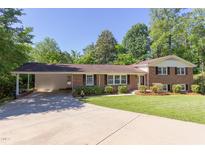 Charming brick home with a well-manicured lawn and a convenient carport, perfect for outdoor living at 4300 Edgehill Ct, Raleigh, NC 27612