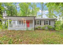 Charming single-story home showcasing a welcoming front porch and vibrant red front door at 5613 Deerborn Dr, Apex, NC 27539