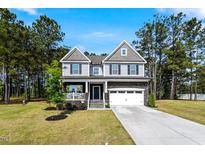 Charming two-story home with a covered front porch and well-manicured lawn at 7729 Calcutta Dr, Willow Springs, NC 27592