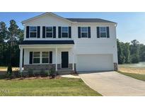 Charming two-story home with a traditional design, white siding, dark shutters, and a well-manicured lawn at 85 Cordoba Dr, Franklinton, NC 27525