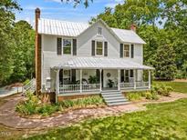 Charming two-story home featuring a welcoming front porch, landscaped yard, and classic architectural details at 967 Bynum Rd, Pittsboro, NC 27312