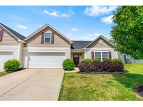 Charming home with a manicured lawn and a two-car garage under a bright blue sky at 1004 Gold Cir, Mebane, NC 27302