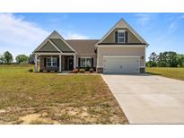Charming home featuring a two-car garage, well-manicured lawn, and a welcoming entrance at 105 Seminole Fields Dr, Broadway, NC 27505