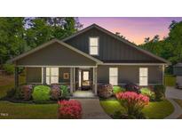 Charming home featuring a welcoming front porch and beautifully landscaped garden with colorful shrubs at 109 Rustler Rd, Louisburg, NC 27549