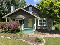 Charming home with a quaint porch, yellow door, and well-maintained front yard at 209 E Winston St, Youngsville, NC 27596