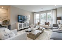 Modern living room with large windows, plush seating, area rug, and entertainment center at 2301 Bay Minette Sta # 538, Apex, NC 27502
