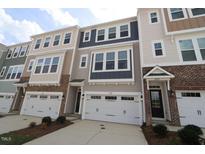 View of townhomes featuring a two-car garage and a mix of siding and stone on the facade at 2323 Hunter Woods Dr # 566, Apex, NC 27502