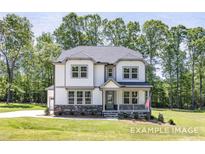 Charming two-story home featuring stone accents, inviting porch, and a well-manicured lawn at 440 Golden Dragonfly St, Wake Forest, NC 27587