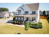 Charming two-story home boasts a welcoming front porch, beautiful landscaping, and a well-manicured lawn at 536 Adkins Ridge Rd, Rolesville, NC 27571