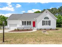 Charming home with white siding, black shutters, red front door and well-manicured landscaping at 5612 Sandy Trail Dr, Knightdale, NC 27545