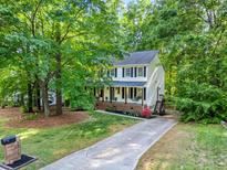 Charming two-story home featuring a welcoming front porch and a well-manicured front yard surrounded by mature trees at 5701 Hadrian Dr Dr, Durham, NC 27703