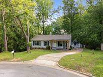 Charming single-story home with a welcoming front porch and lush landscaping at 6125 Bellow St, Raleigh, NC 27609