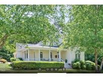 Charming home with a manicured lawn and a welcoming front porch with decorative columns at 7716 Micklewaithe Ct, Wake Forest, NC 27587