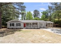 Charming one-story home featuring a red front door, gray brick, and a well-maintained yard at 7824 Knightdale Blvd, Knightdale, NC 27545