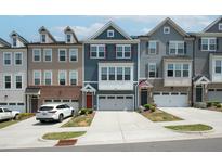 Modern townhomes feature multi-toned exteriors and attached garages with driveways at 805 Grafton Peak Lane Ln, Apex, NC 27523
