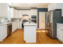 Bright kitchen with white cabinetry, stainless steel appliances, island, and hardwood floors at 816 Roanoke Dr, Cary, NC 27513