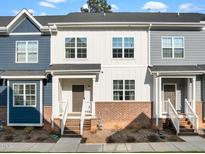 Charming townhome featuring a mix of blue, white, and gray siding with brick accents and a welcoming front porch at 820 Laurel Gate Dr, Wake Forest, NC 27587