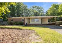Charming single-story home with a brick facade, covered carport and mature landscaping at 108 Jefferson Dr, Durham, NC 27712