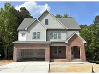Charming two-story home with a brick-accented facade and attached two-car garage, surrounded by lush greenery at 2408 Eagle Shot Ct # 4, Fuquay Varina, NC 27526