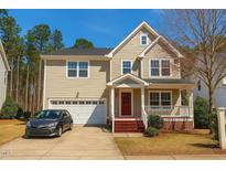 Charming two-story home featuring a red front door, a front porch, and an attached two-car garage at 3032 Kilarney Ridge Loop, Cary, NC 27511