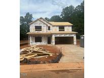Two-story home under construction with visible framing and sheathing, driveway, and a lush green backdrop at 314 Shiloh Way, Mebane, NC 27302