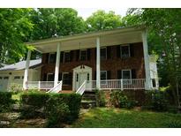 Charming brick home with a welcoming front porch and beautiful landscaping at 4113 Oak Park Rd, Raleigh, NC 27612