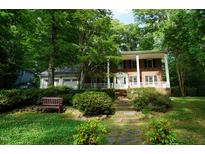 Charming brick home with a covered porch, lush landscaping, and a welcoming entrance at 4113 Oak Park Rd, Raleigh, NC 27612
