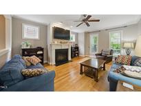 Inviting living room with a fireplace, hardwood floors, and comfortable seating arrangements at 420 Marsh Landing Dr, Holly Springs, NC 27540