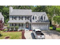 Charming two-story home featuring a well-manicured lawn, two-car garage, and welcoming front porch at 4309 Birmingham Way, Raleigh, NC 27604