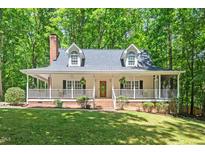 Charming traditional-style home featuring a brick chimney and a welcoming front porch at 524 Preston Andrews Rd, Bahama, NC 27503