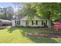 Charming single-story home with a well-manicured lawn and a cozy front porch nestled under lush greenery at 5300 Whippoorwill St, Durham, NC 27704