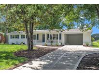 Charming, renovated home featuring a painted brick exterior, mature landscaping, and an attached carport at 5718 Woodcrest Dr, Raleigh, NC 27603