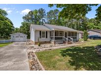 Charming single-story home featuring a screened-in front porch and a detached garage, enhanced by meticulous landscaping at 609 Chivalry Dr, Durham, NC 27703