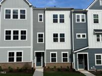 Charming new construction townhome showcases neutral colors and a well-manicured lawn at 808 Hillfarm Dr, Wake Forest, NC 27587