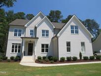 Stunning two-story brick home featuring manicured landscaping and a welcoming front entrance at 1444 Old Apex Rd, Cary, NC 27513