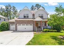 Charming two-story home boasts stone accents, a three-car garage, and a well-manicured lawn at 1613 Waddell Ct, Durham, NC 27703