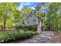 Charming two-story home with an attached garage and complemented by lush greenery and mature trees at 1767 Quince Loop, Sanford, NC 27332