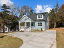 Charming light blue home featuring a welcoming front porch and newly paved driveway at 2015 Cheek Rd, Durham, NC 27704