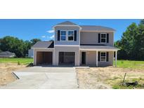 New two-story home with a two-car garage and lovely landscaping on a sunny day at 2535 Whitetail Rd, Nashville, NC 27856