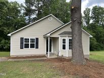 Charming single-story home featuring neutral siding, black shutters, and well-maintained front yard at 284 Irvan St, Clayton, NC 27520